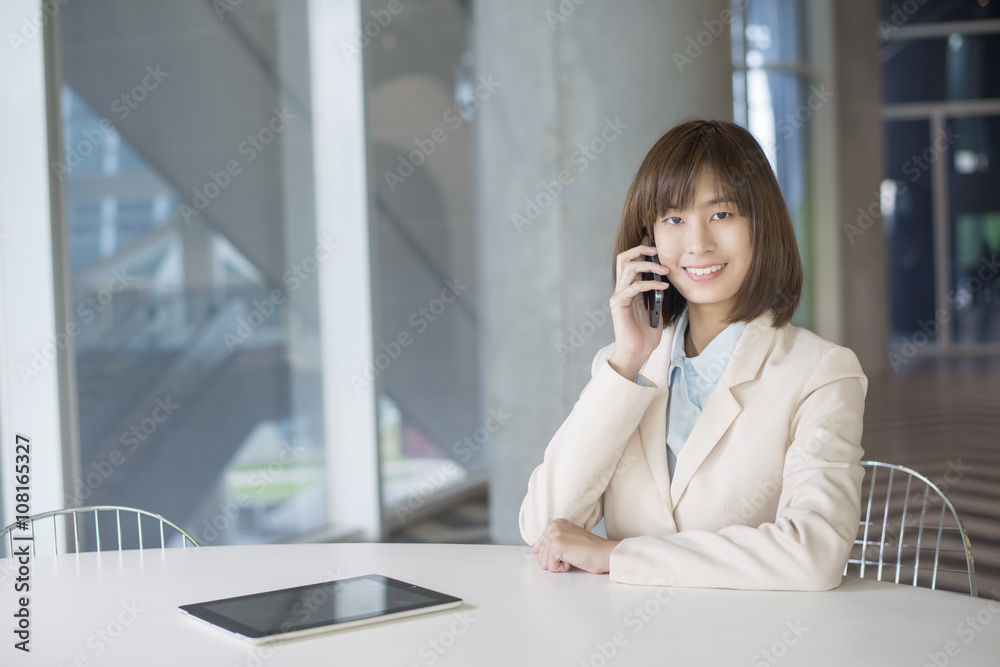 Attractive asian business woman using smartphone on workplace Attractive asian business woman using smartphone on workplace