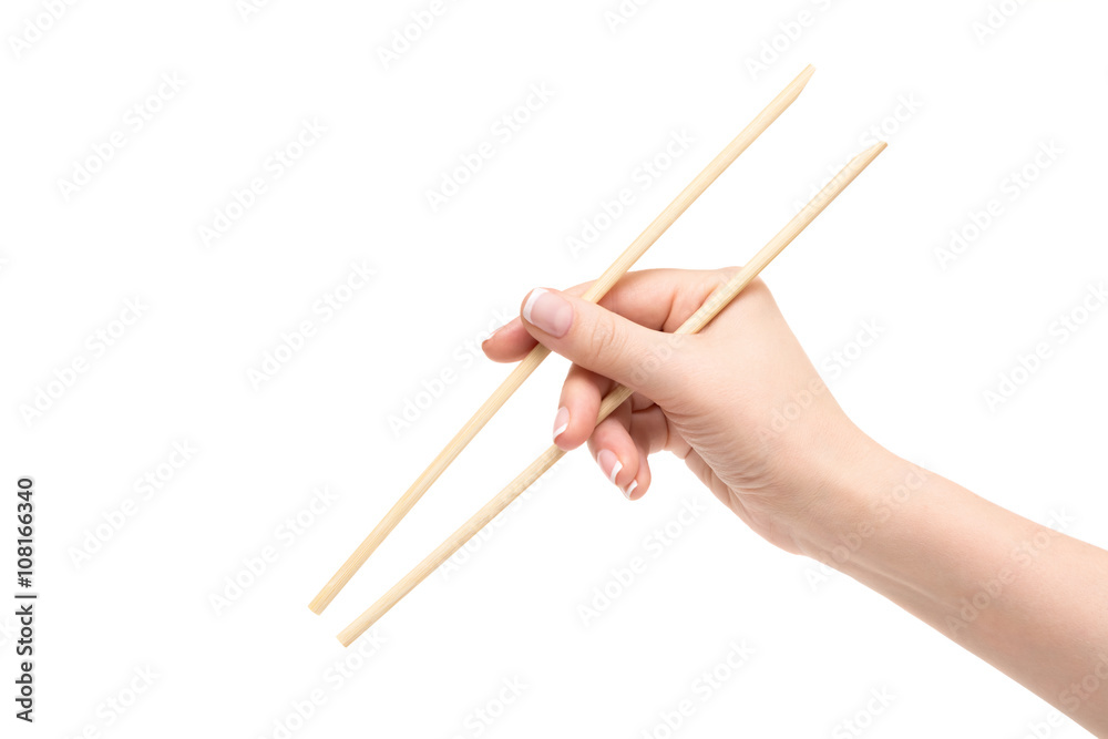 Isolated female hand holds chopsticks on a white background. Isolated female hand holds chopsticks on a white background.