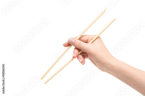 Isolated female hand holds chopsticks on a white background.