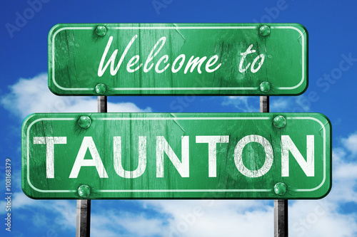 taunton vintage green road sign with blue sky background photo