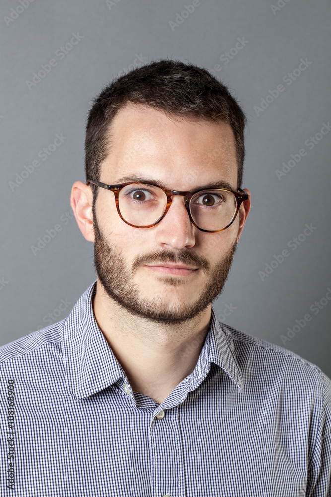 surprise concept - portrait of an introvert young bearded entrepreneur with eyeglasses having a great idea or finding a business solution, grey background studio. surprise concept - portrait of an introvert young bearded entrepreneur with eyeglasses having a great idea or finding a business solution, grey background studio.