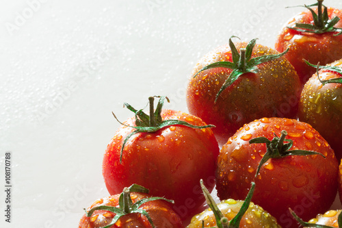 Fotografie Pomodori sardi freschi bagnati su sfondo chiaro