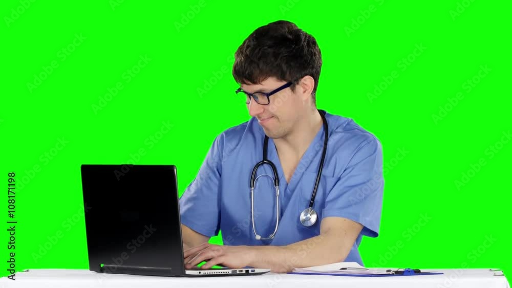 Friendly, happy male doctor in the office using laptop. Green screen Friendly, happy male doctor in the office using laptop. Green screen