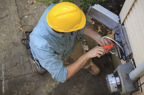 Caucasian worker installing cable box