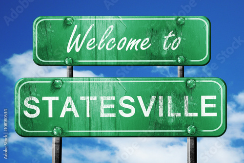statesville vintage green road sign with blue sky background photo