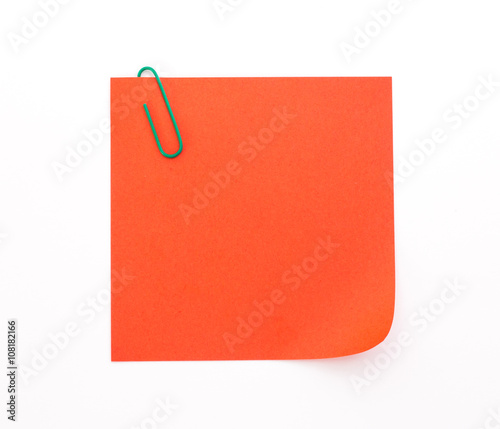 red sheet of paper with green paper clip on a white background