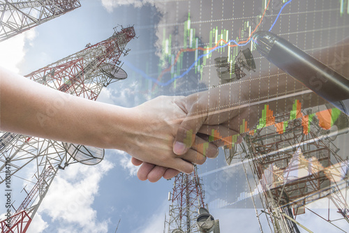 Double explosure with businesss charts , handshake and Telecommu
