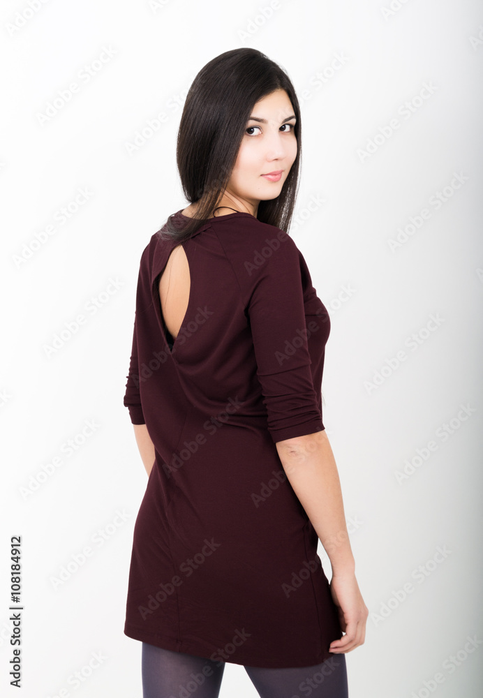 Beautiful asian young brunette in a short dark dress standing and posing Beautiful asian young brunette in a short dark dress standing and posing