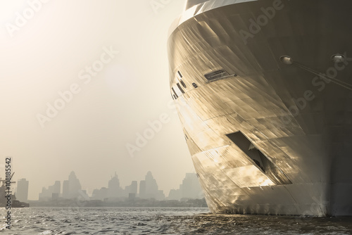 bow of large ship , large aBangkok city in the background at eve