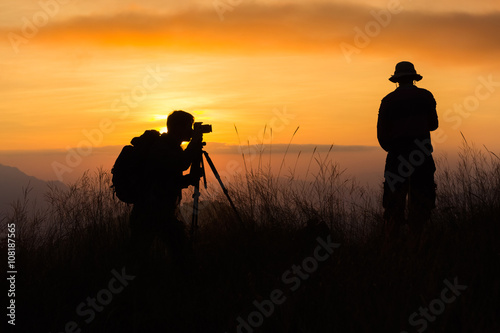 Silhouette of a young photographer during the sunset