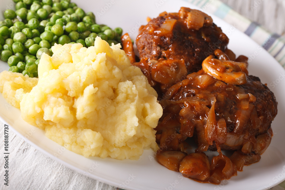 Salisbury steak with mashed potatoes and green peas close-up on a plate. horizontal
Salisbury steak with mashed potatoes and green peas close-up on a plate. horizontal