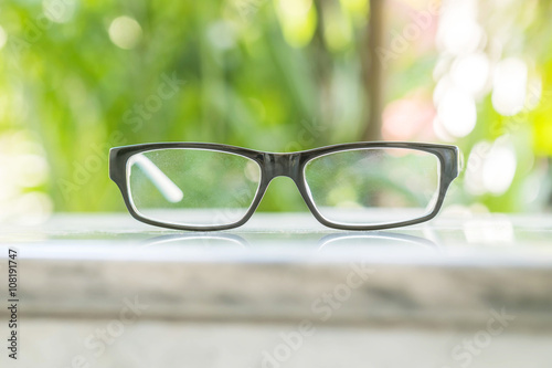 Glasses on table in the park with blurred tree background