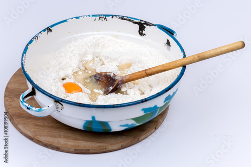 Raw egg in the flour with wooden scoop