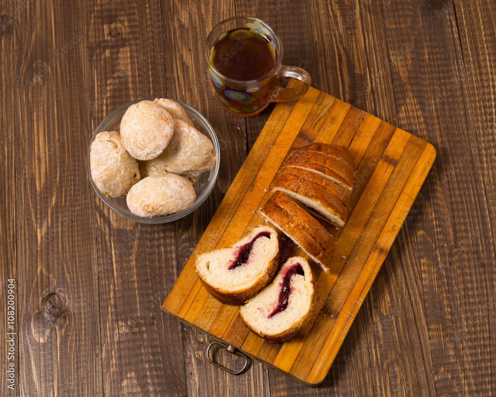 Cutted loaf with buns and tea