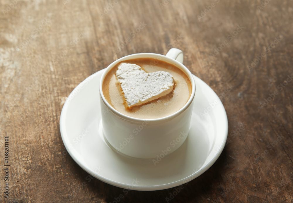 Obraz premium Cup of coffee with marshmallow on wooden table