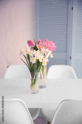 Beautiful tulips and irises on dinning table , indoors