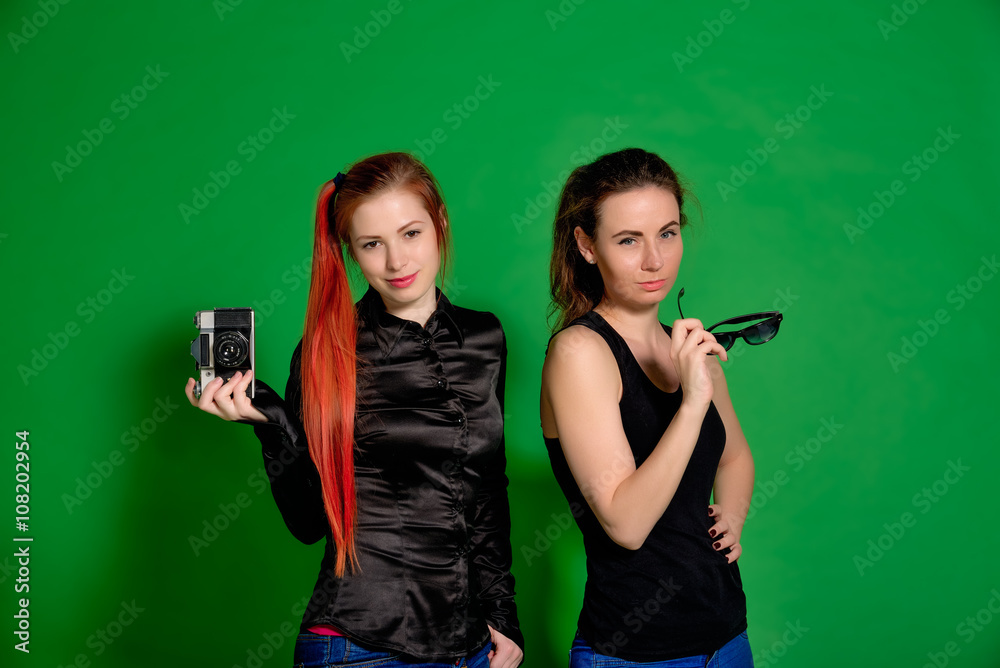 Two young women having fun posing and making photos with old cam Two young women having fun posing and making photos with old cam