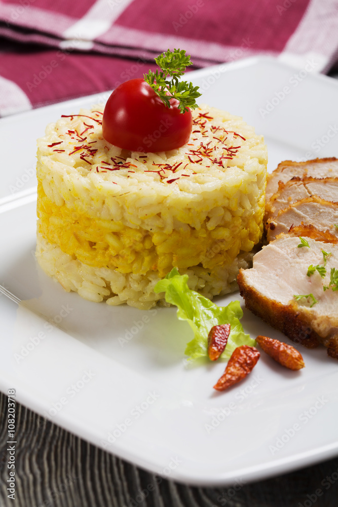 Portion of risotto with roasted chicken.