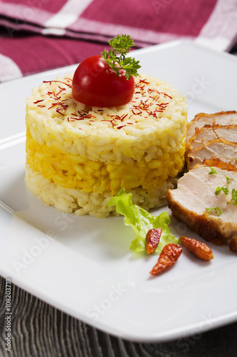 Portion of risotto with roasted chicken.