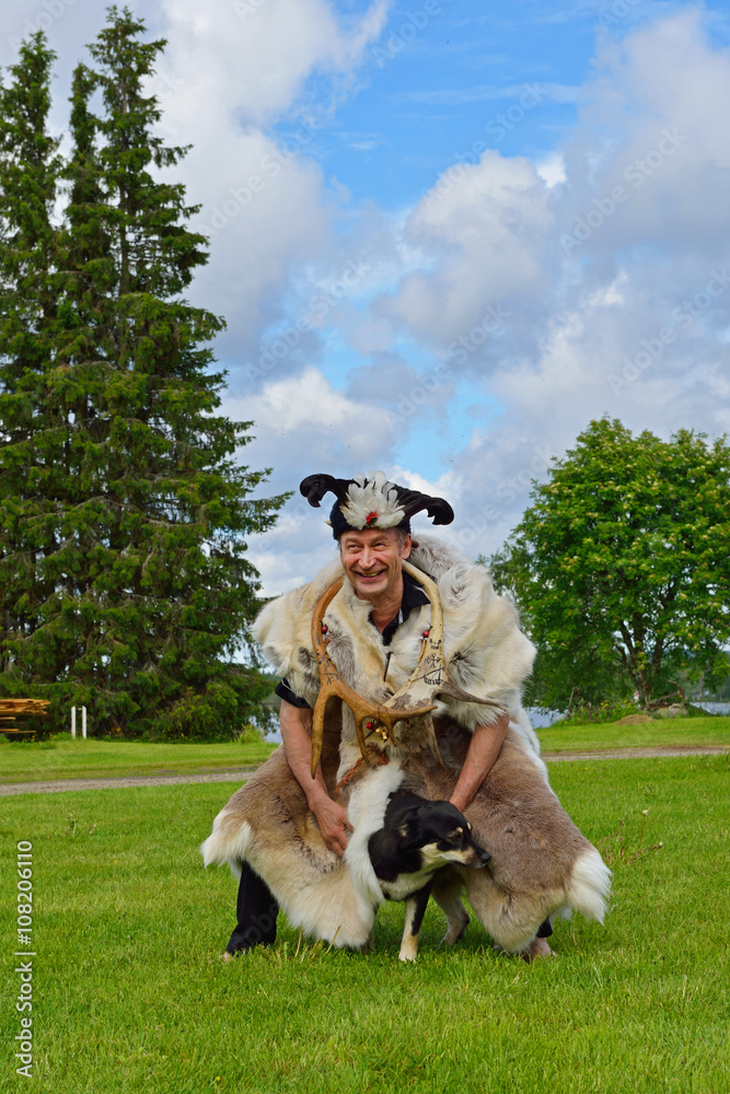 Sami shaman with his assistant dog on field. Northern Finland, Lapland Sami shaman with his assistant dog on field. Northern Finland, Lapland