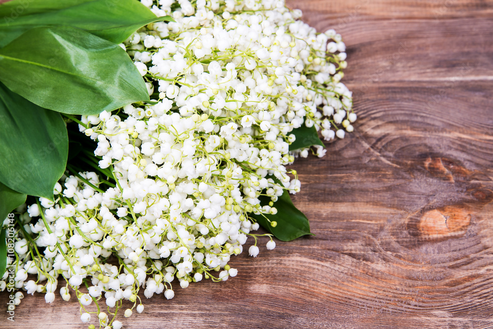 Bouquet of white lilies of the valley in aluminum containers on a wooden background Bouquet of white lilies of the valley in aluminum containers on a wooden background