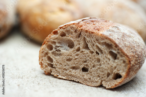 A Half-Cut loaf of home-baked bread on the blurred background of other loafs of bread