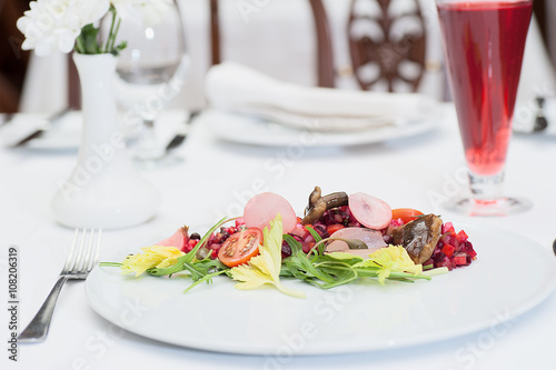 Russian Vinaigrette Salad Served on a Restaurant Table with a Glass of Fruit Juice