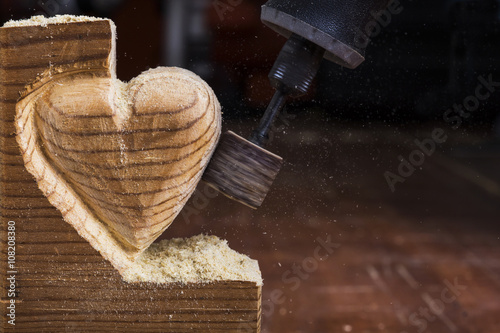 sanding wood in heart shape with a rotary tool