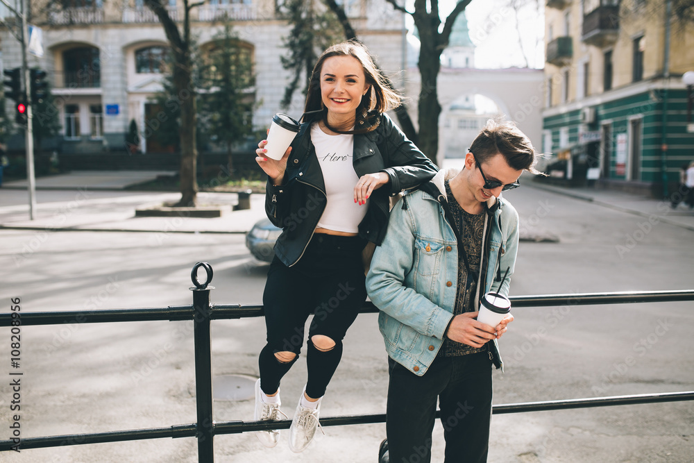 Youth and fashionable couple on the streets drinking coffee.