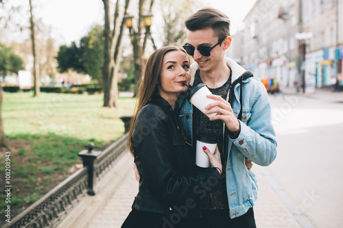 Youth and fashionable couple on the streets drinking coffee.