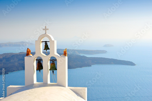 Unique bell tower on Santorini Island, Greece. The view toward Caldera sea waiting for sunset. photo