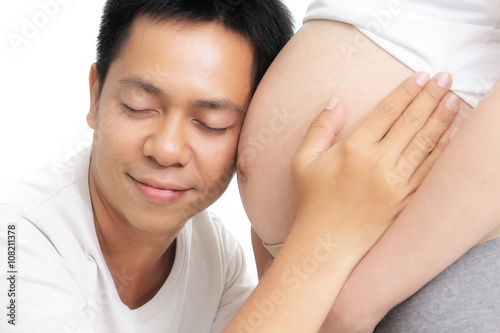 Young Asians are happy with the listening sound of children in the womb of his wife
