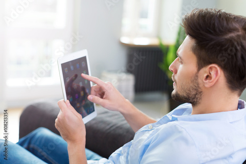 Man sitting on couch with digital tablet
