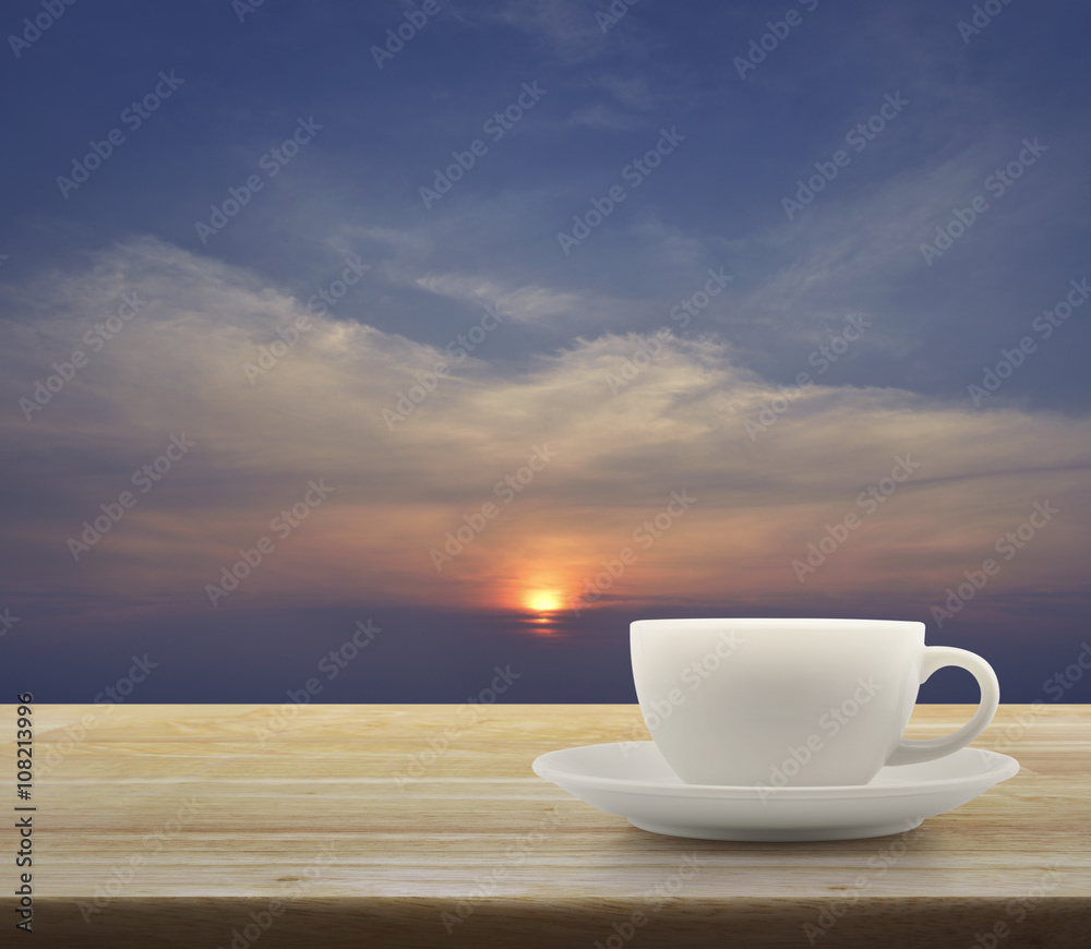 White cup on wooden table with sunset sky White cup on wooden table with sunset sky