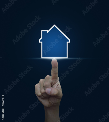 Hand pressing house icon with copy space on blue background  Rea