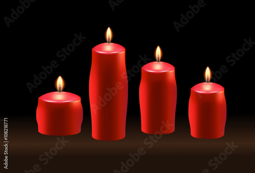 Burning red candles on black background