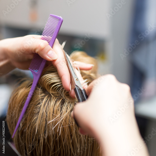 Female hair cutting scissors in beauty salon