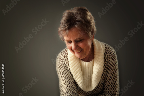 Vriendelijk lachende vrouw die naar beneden kijkt photo