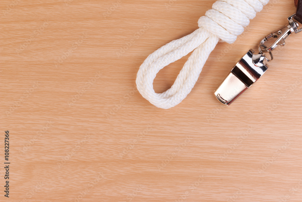 Metal whistle, yellow scout scarf and scout rope on wooden background. Metal whistle, yellow scout scarf and scout rope on wooden background.