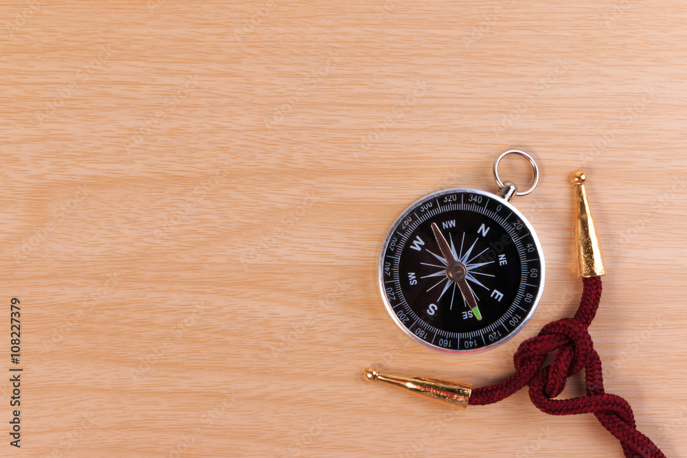 Boy scouts knot, the square knot and classic compass on wooden table. Boy scouts knot, the square knot and classic compass on wooden table.