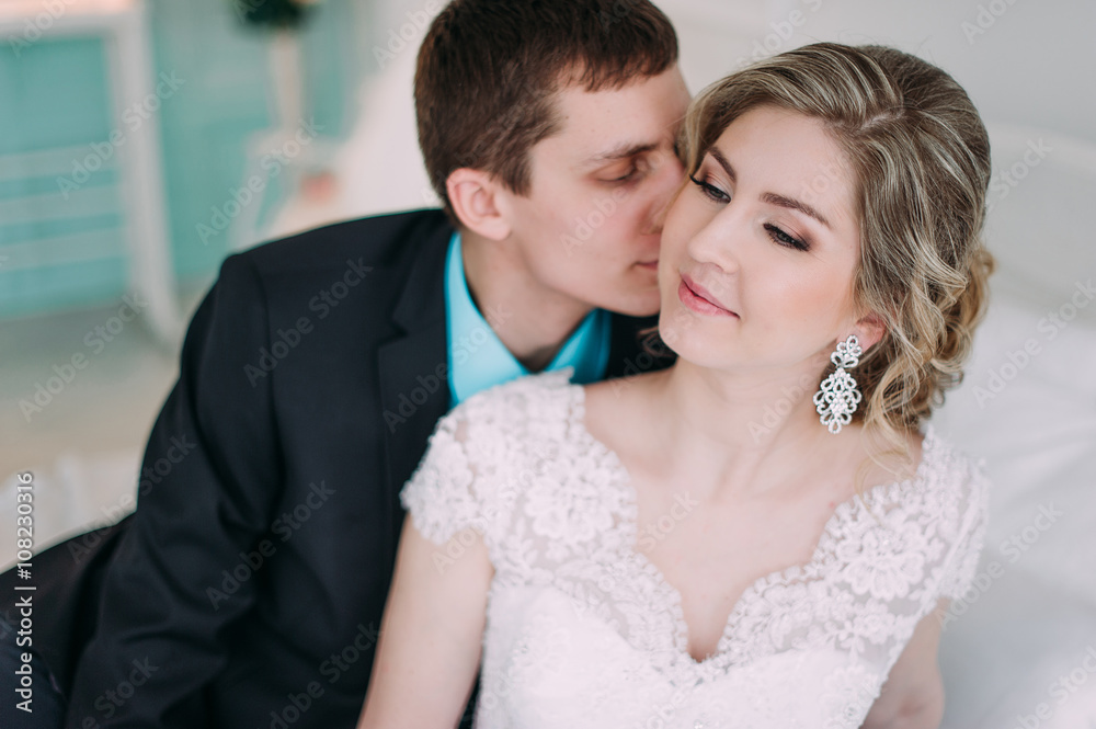 Happy couple. Wedding photo shoot in the white studio with wedding decor kisses, hugs