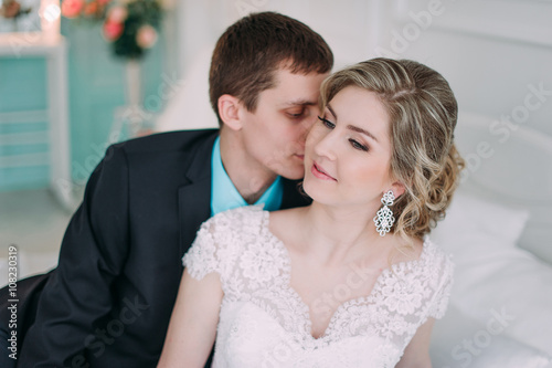 Happy couple. Wedding photo shoot in the white studio with wedding decor kisses, hugs