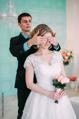 Happy couple. Wedding photo shoot in the white studio with wedding decor kisses, hugs