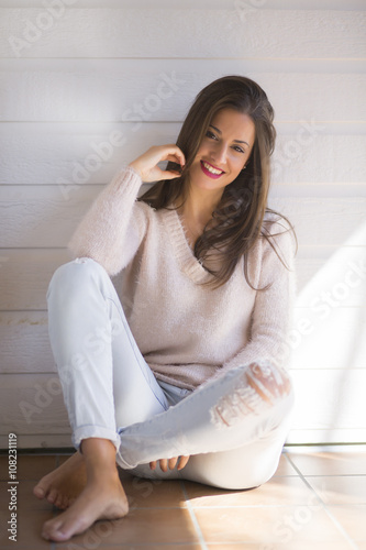 Smiling young woman sitting on the floor photo