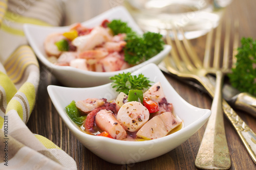 seafood salad in bowl on brown wooden background