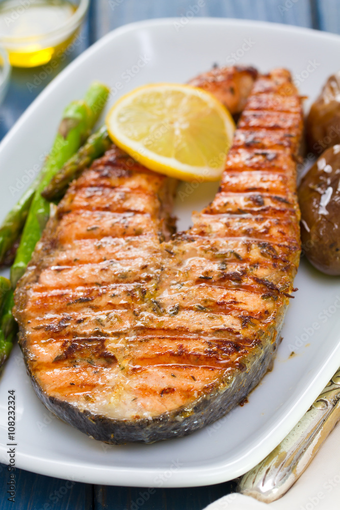 grilled salmon with lemon and vegetables on white dish