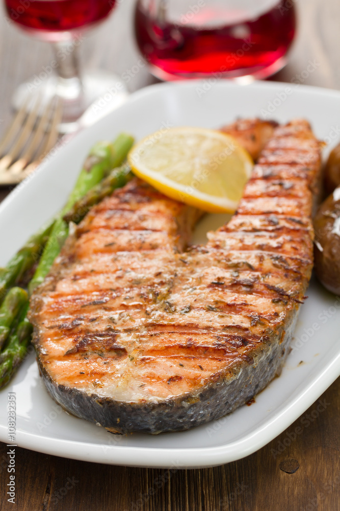 salmon with lemon and vegetables on white dish