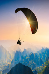 Fotobehang Luchtsport Paragliden boven groen berglandschap  © Bashkatov
