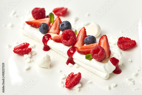 meringue cake decorated with fruit, strawberries, raspberries, b