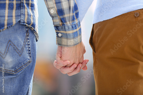Two homosexuals holding hands outside
